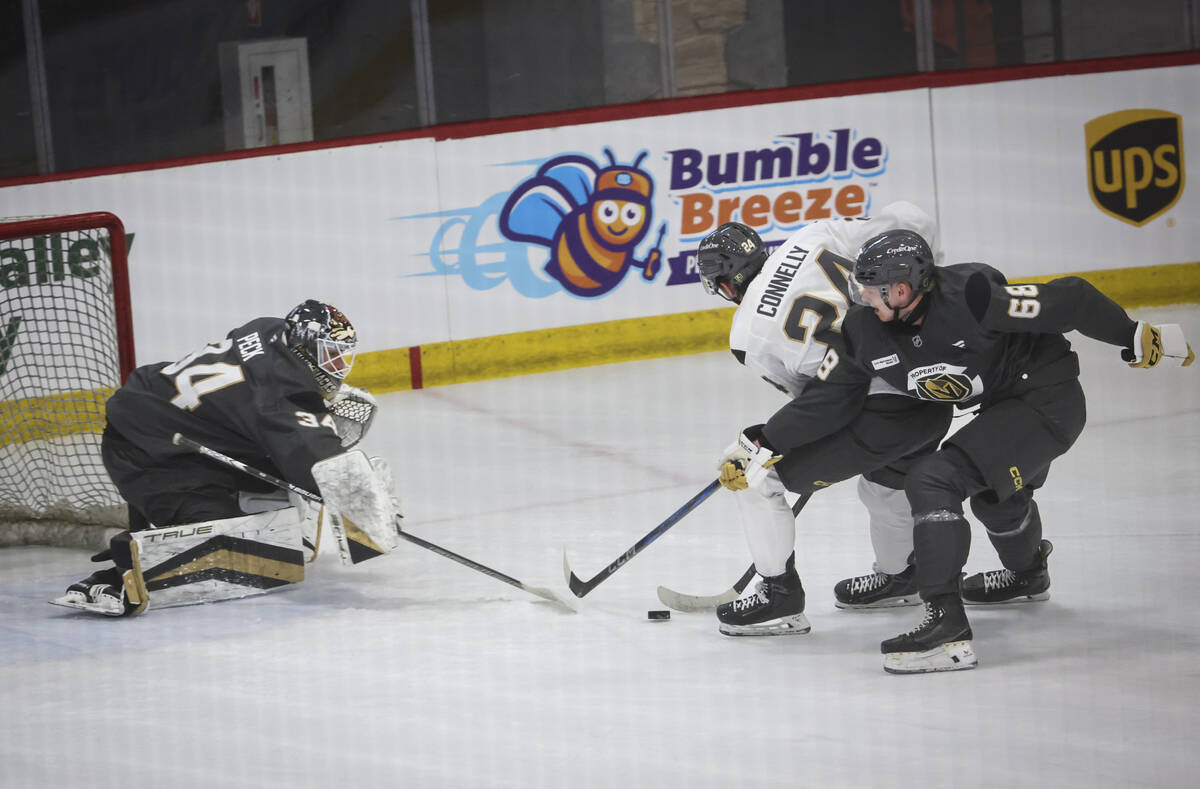 Golden Knights goaltender Stephen Peck (34) and defenseman Peteris Bulans (68) defend against f ...