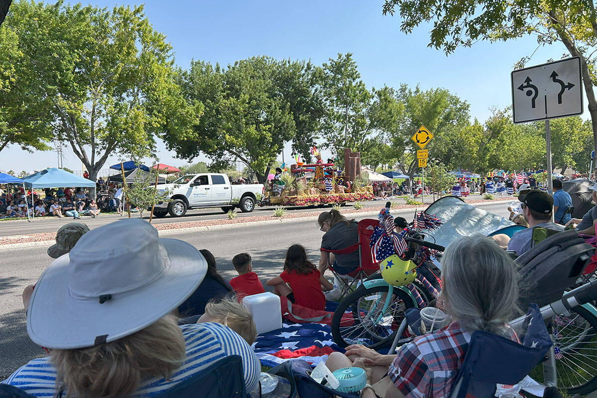 Parade attendees sit while watching a float go down the road at the Summerlin Patriotic Parade ...