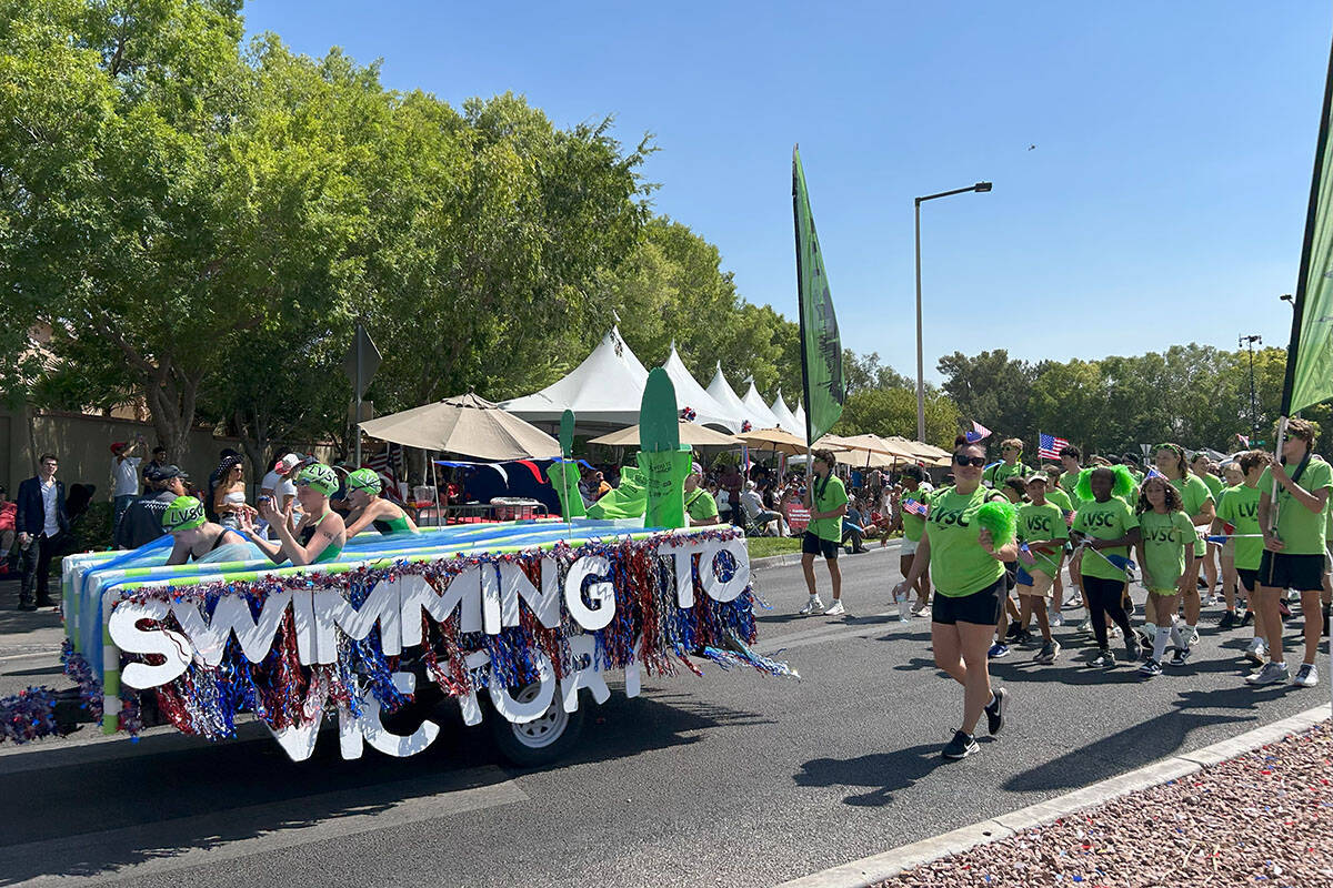 A parade float sponsored by the Las Vegas Swim Club drives by parade onlookers at the Summerlin ...
