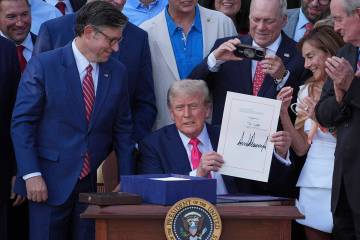 President Donald Trump holds his signed signature bill of tax breaks and spending cuts at the W ...