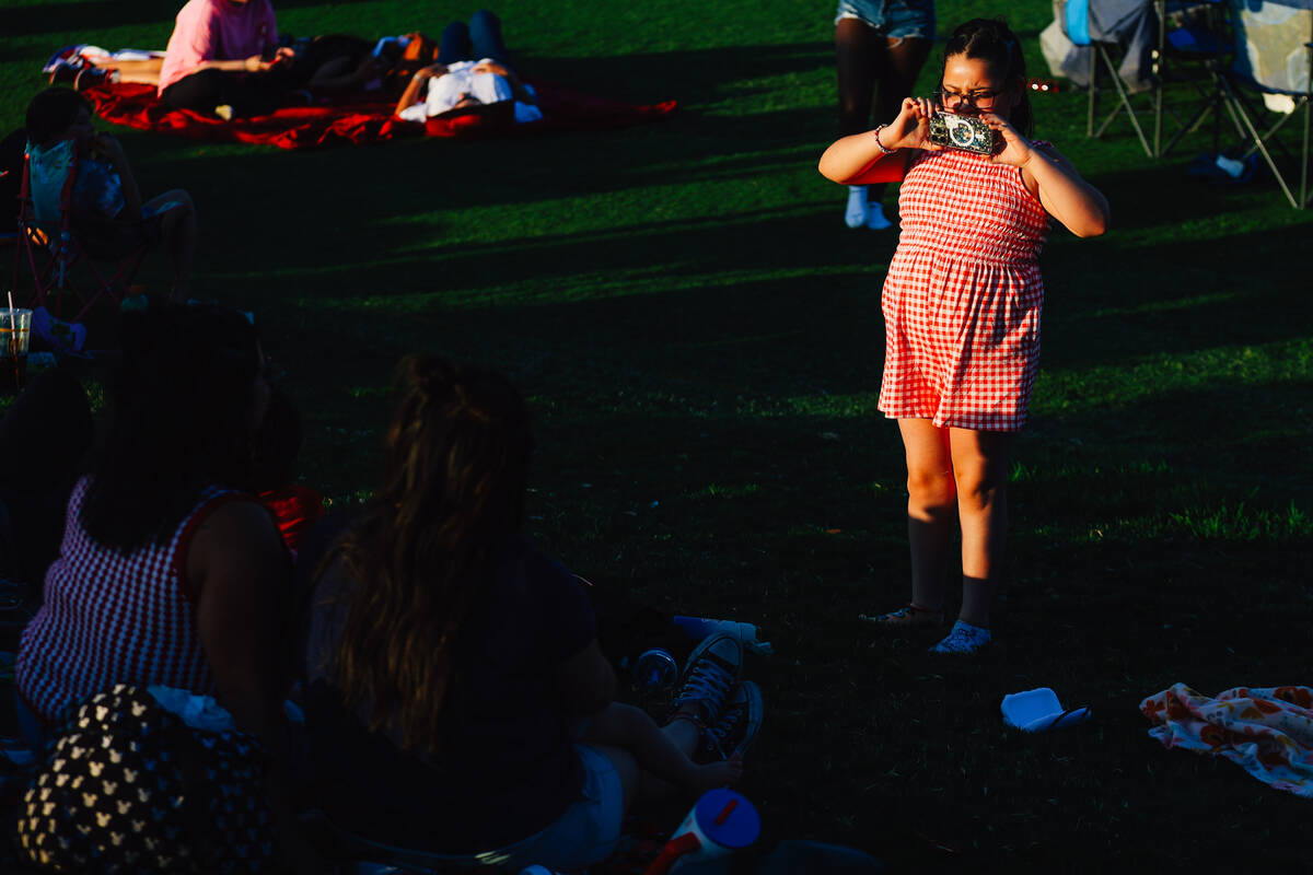 A young photographer takes a photo during a Fourth of July bash at Heritage Park Friday, July 4 ...
