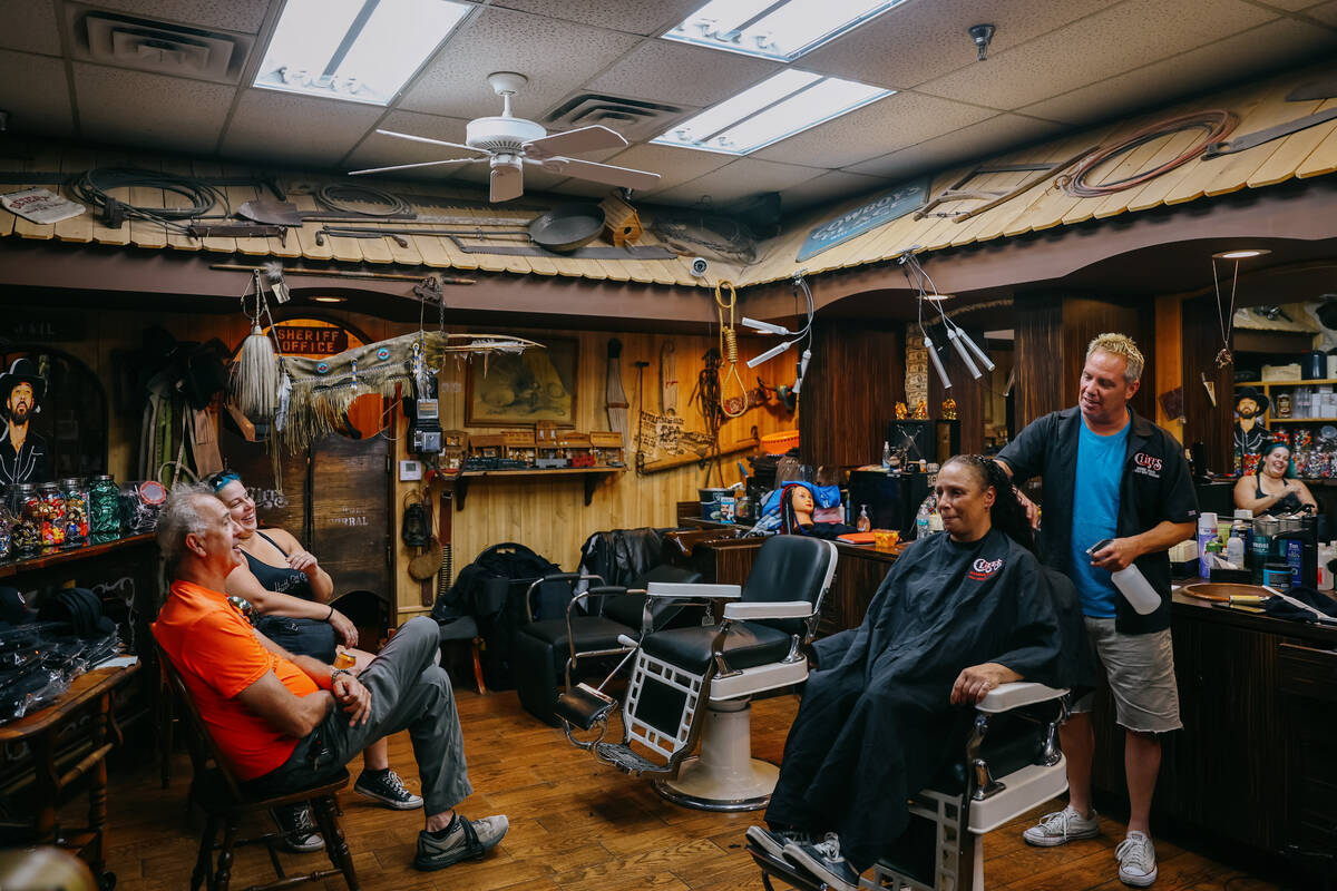 Customers joke around with Devin Ruesch, right, as he cuts hair at Cliff’s Barber Corral ...