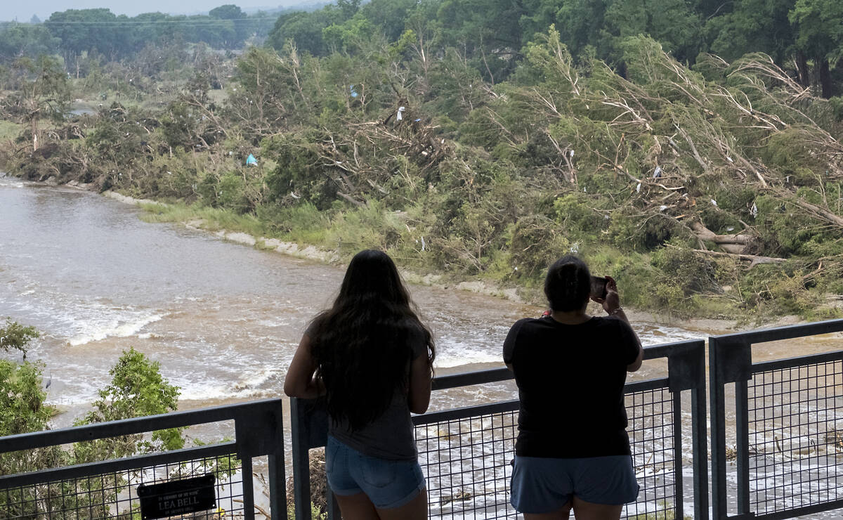 Onlookers review the damage along the Guadalupe River caused by recent flooding, Sunday, July 6 ...