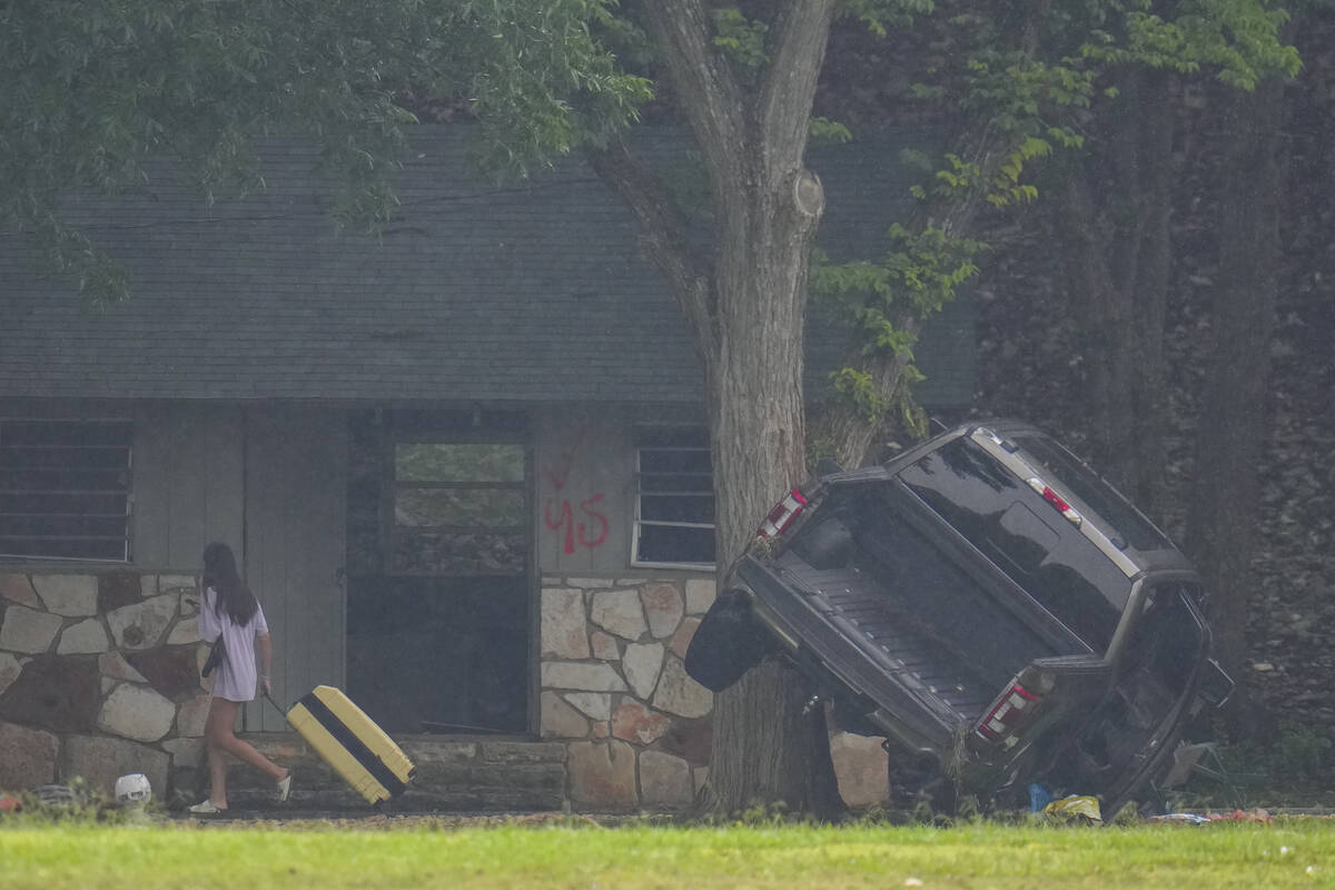 A person pulls luggage at Camp Mystic along the banks of the Guadalupe River after a flash floo ...