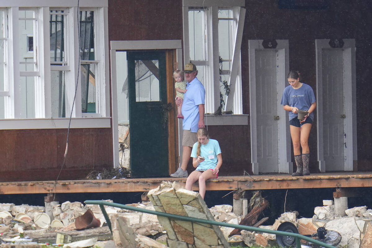 A person salvages a bell from the main building at Camp Mystic along the banks of the Guadalupe ...