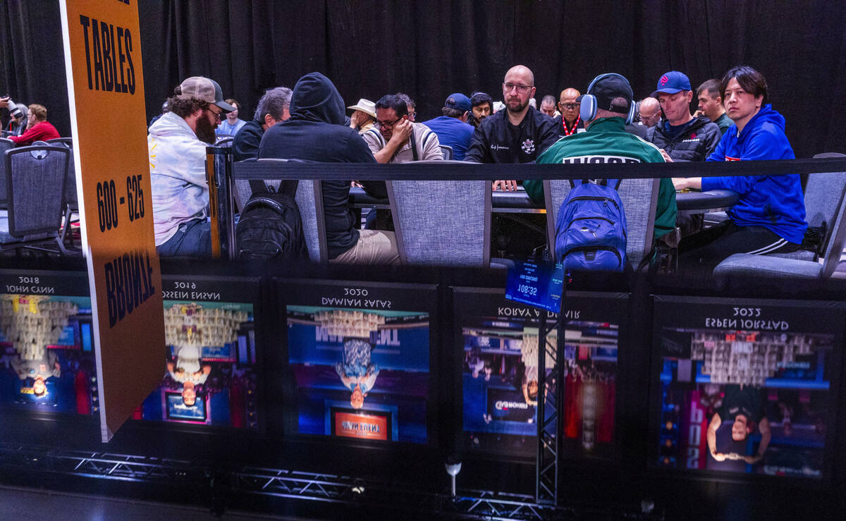 Banners of winning players are reflected near the main table as play continues during the openi ...
