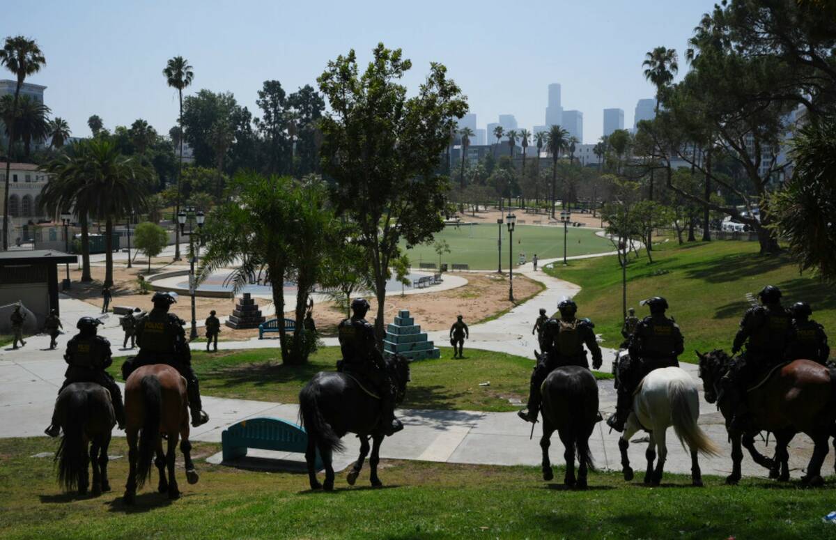 Federal agents ride on horseback at MacArthur Park Monday, July 7, 2025, in Los Angeles. (AP Ph ...
