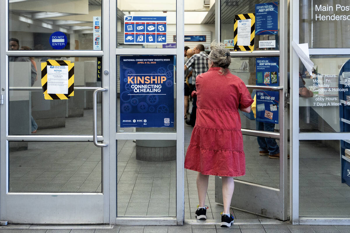 A woman walks past a “closed” notice at the United States Post Office in Henderso ...