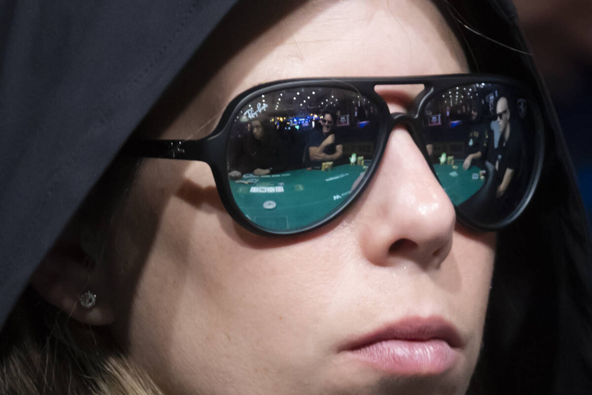 The poker table is reflected in the glasses of Loni Hui during day 3 of the World Series of Pok ...