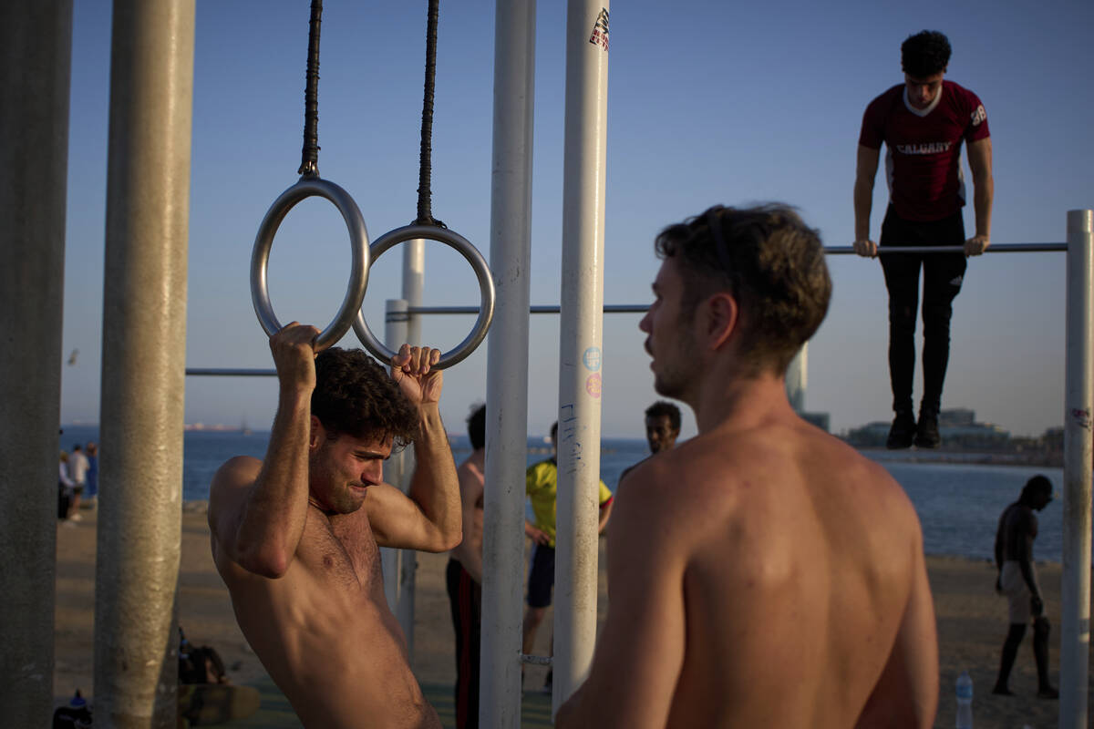 People work out in an open-air gym next to the beach in Barcelona, Spain, Tuesday, June 25, 202 ...