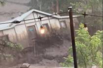 In this image taken from video, a house is carried away by flash flooding behind a house in Rui ...