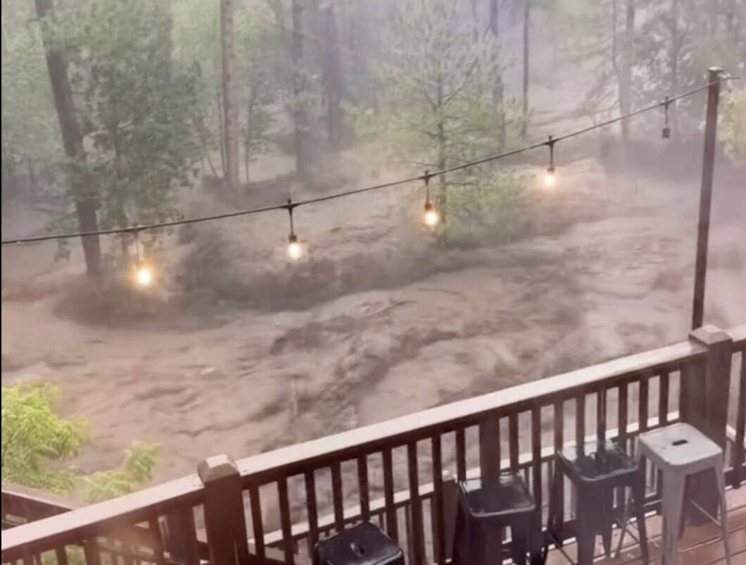 In this image taken from video, flash flooding is seen behind a house in Ruidoso, N.M., Tuesday ...