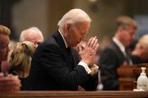 Former US President Joe Biden kneels in prayer during funeral services for Mark and Melissa Hor ...