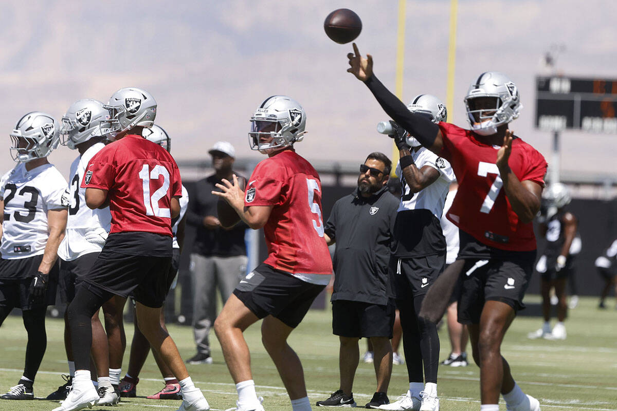 Raiders quarterback Geno Smith (7) throws the ball as quarterbacks Aidan O'Connell (12) and Ca ...