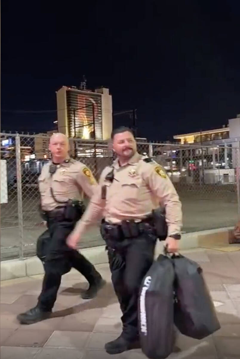 This video screenshot shows Metro officers walking past Karlin Martinez and Cesar Corrales befo ...