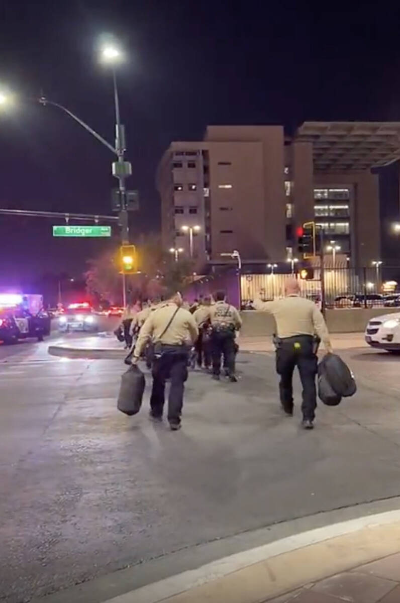 This video screenshot shows one person in a group of Metro officers gesturing to others to appr ...