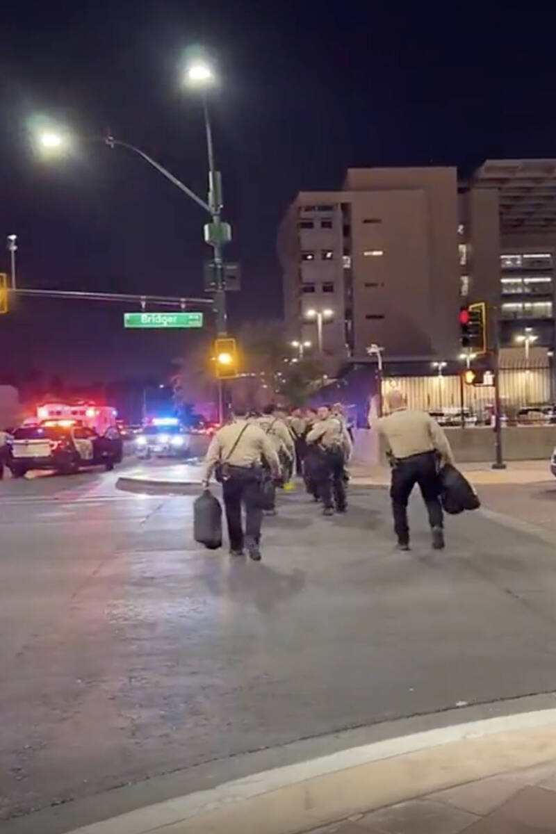 This video screenshot shows one person in a group of Metro officers gesturing to others to appr ...