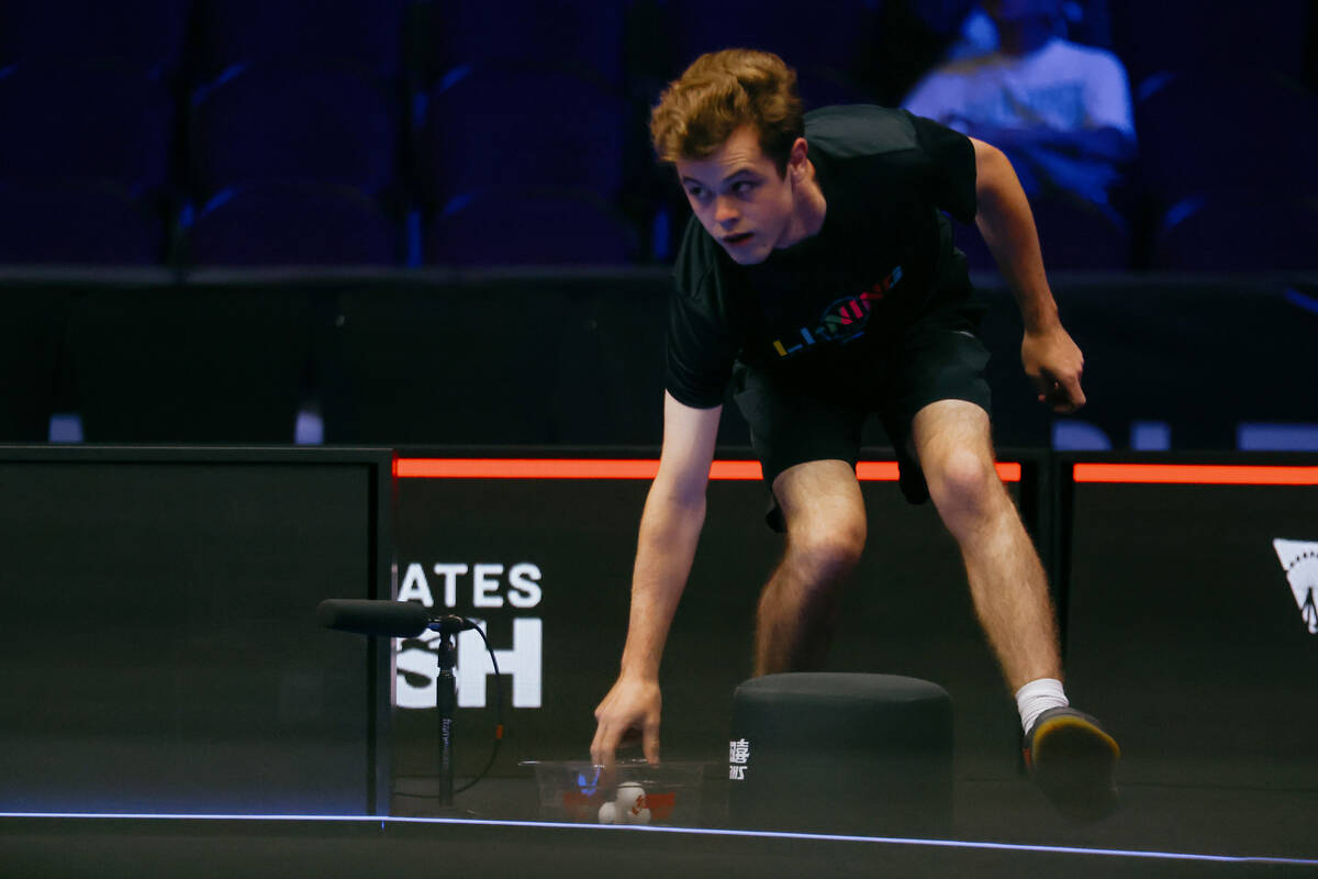 A ball boy drops a retrieved ball into a small bucket during a match between Alexis Lebrun of F ...