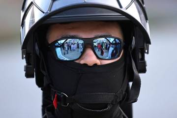 FILE - A U.S. Customs and Border Patrol agent looks on during a protest outside the Federal Bui ...