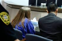 A 12-year-old girl, center, accused of fatally stabbing her father, appears in court with her a ...