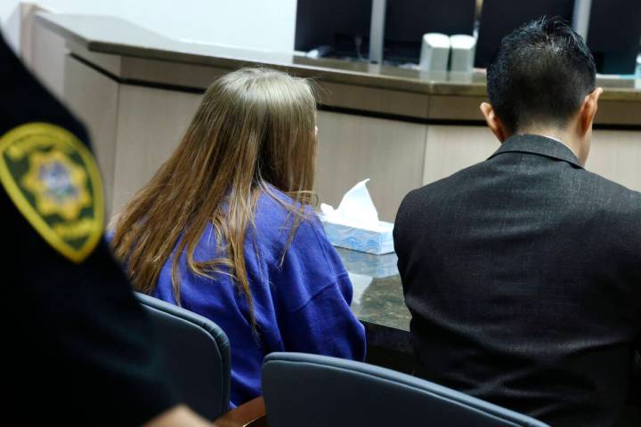 A 12-year-old girl, center, accused of fatally stabbing her father, appears in court with her a ...
