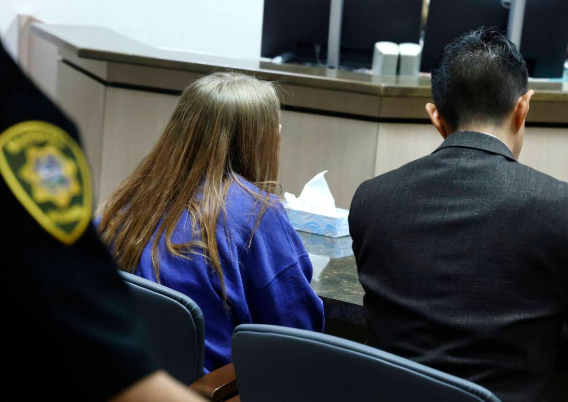 A 12-year-old girl, center, accused of fatally stabbing her father, appears in court with her a ...