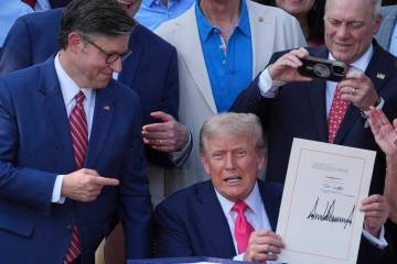House Speaker Mike Johnson of La., points to President Donald Trump after he signed his signatu ...