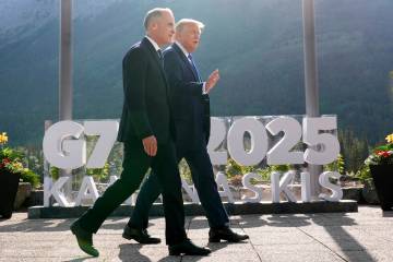 Canada's Prime Minister Mark Carney walks with President Donald Trump after a group photo at th ...