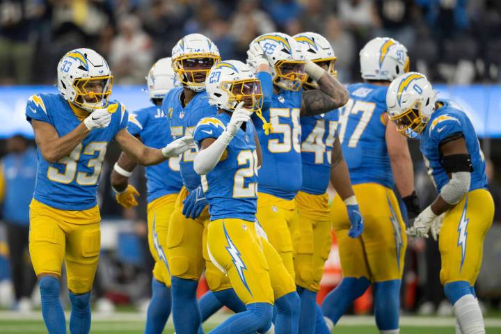 Los Angeles Chargers players huddle during an NFL football game against the Denver Broncos, Thu ...