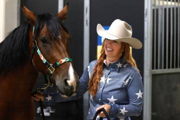 Heidi Brown, a local competing in the Mustang Challenge, pets her bay pinto mustang, Raya, insi ...