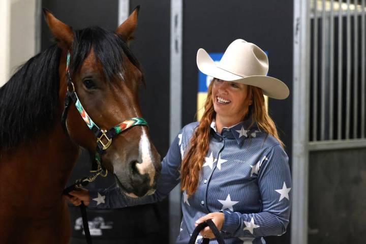 Heidi Brown, a local competing in the Mustang Challenge, pets her bay pinto mustang, Raya, insi ...