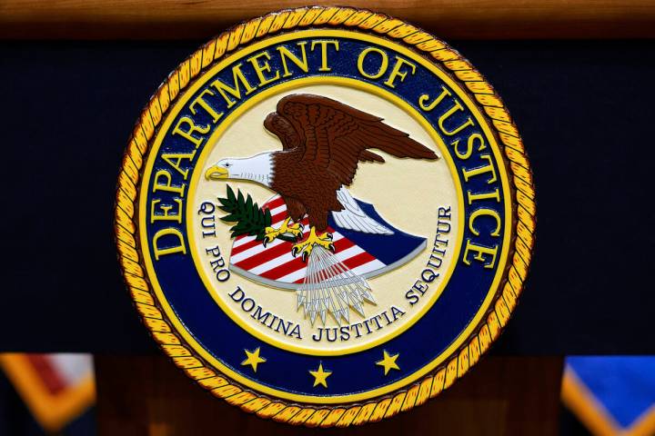 The U.S. Department of Justice logo is seen on a podium before a press conference with Attorney ...