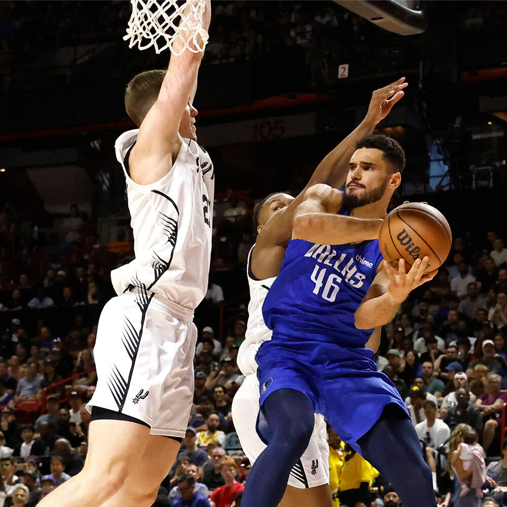 Dallas Mavericks forward Gabe McGlothan (46) tries to shoot for the hoop as San Antonio Spurs' ...