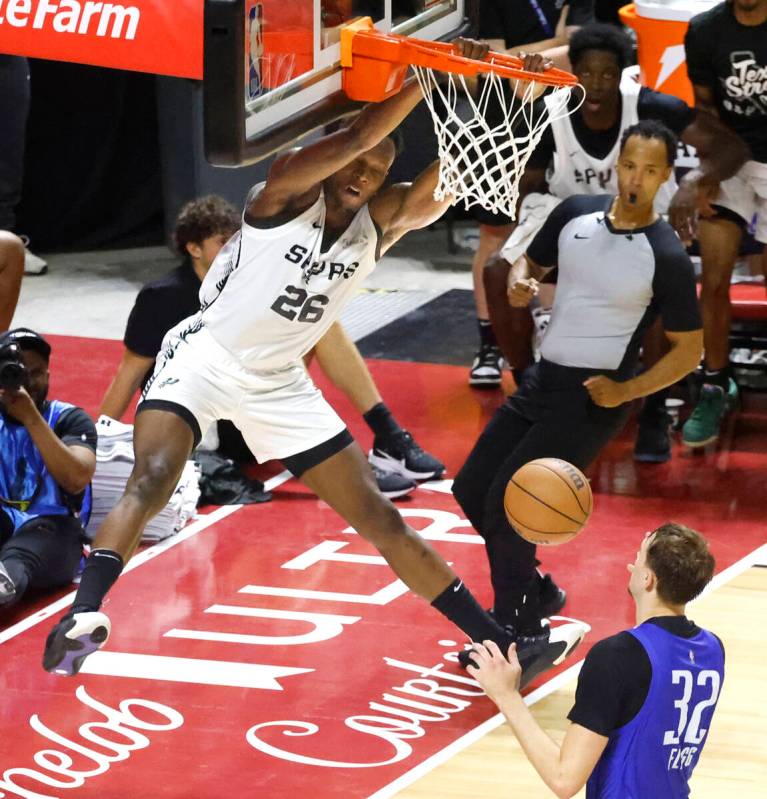 San Antonio Spurs' forward Osayi Osifo (26) dunks as Dallas Mavericks's forward Cooper Flagg (3 ...