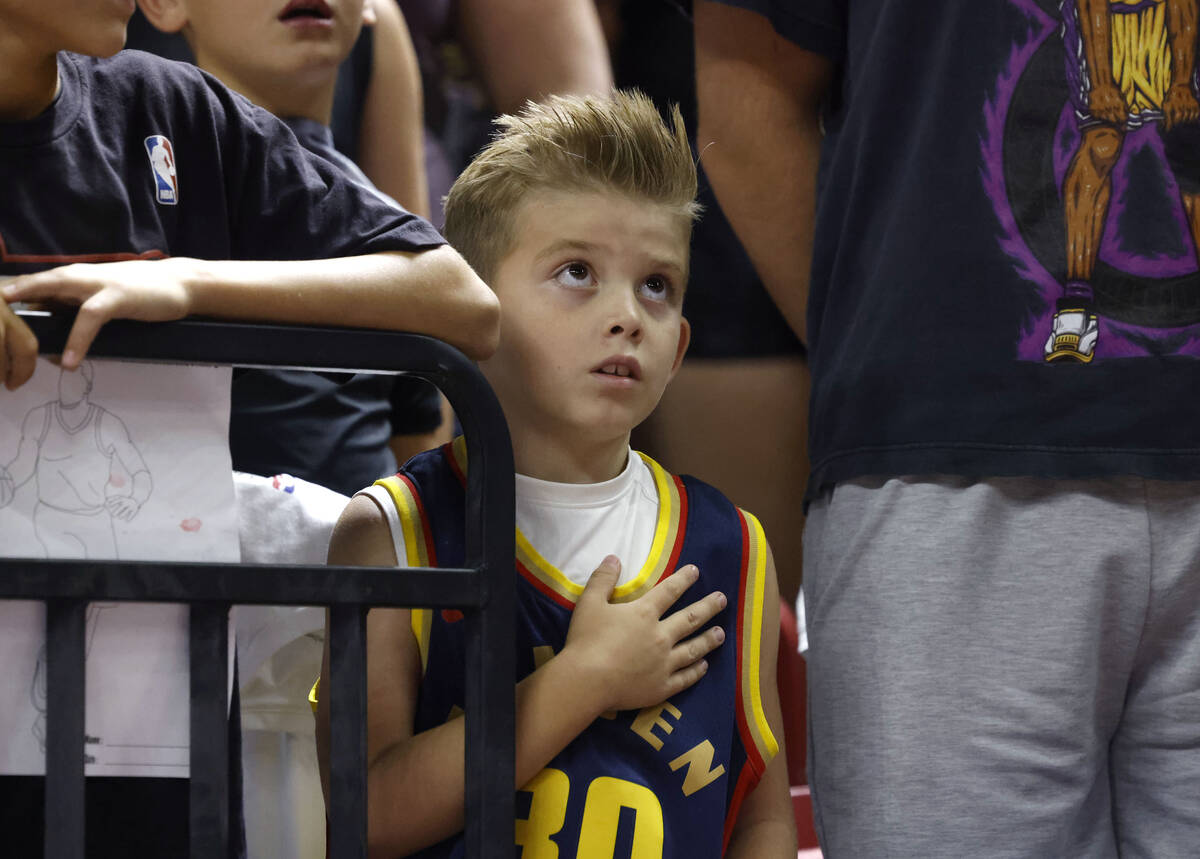 Brady Bennett, 8, places his hand over his heart during the National Anthem before the third da ...