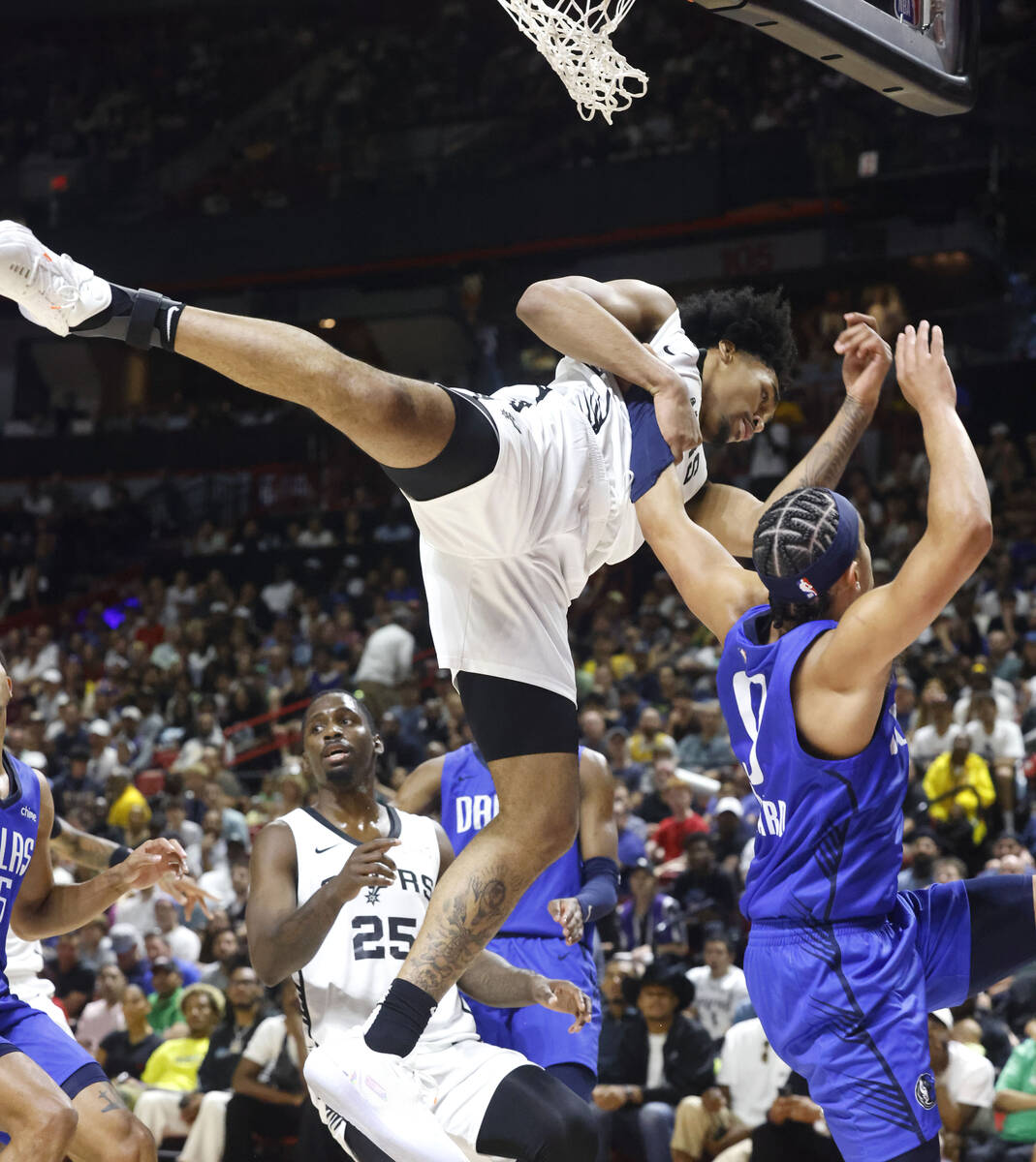 San Antonio Spurs' guard Dylan Harper (2) comes down after blocking a shot from Dallas Maverick ...