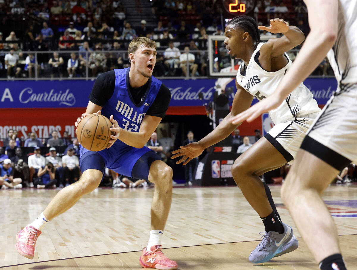 Dallas Mavericks' forward Cooper Flagg (32) looks to pass the ball as San Antonio Spurs' guard ...