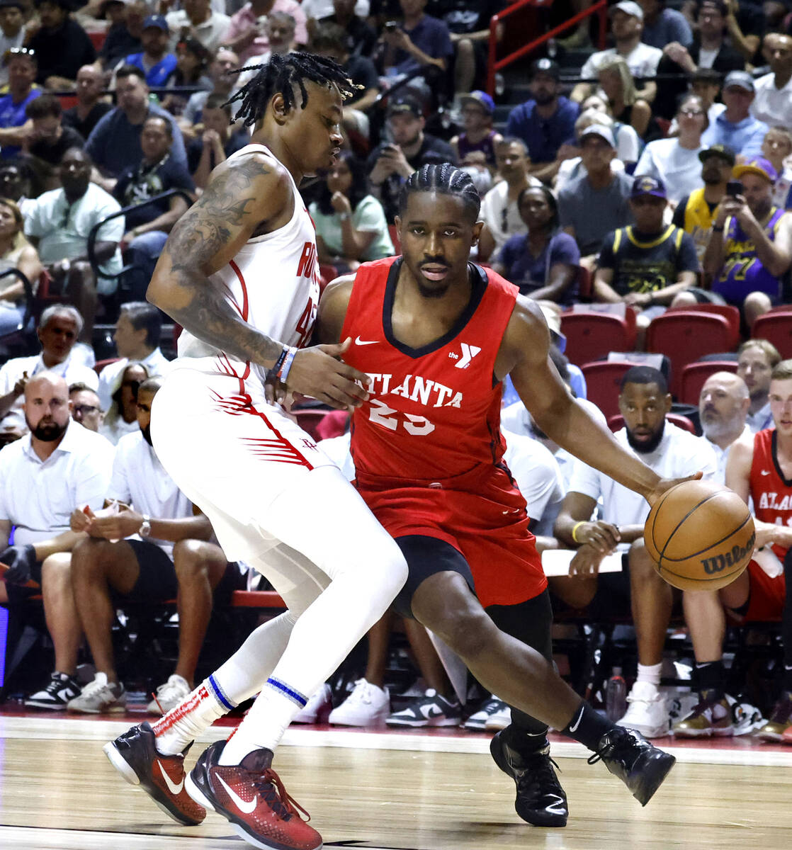 Atlanta Hawks guard Adam Flagler (29) drives past Houston Rockets guard Adonis Arms, left, duri ...