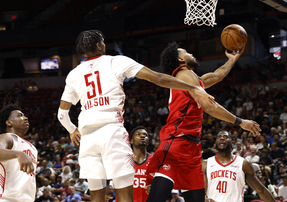 Atlanta Hawks forward Jacob Toppin, right, makes a layup around Houston Rockets guard Mylik Wil ...