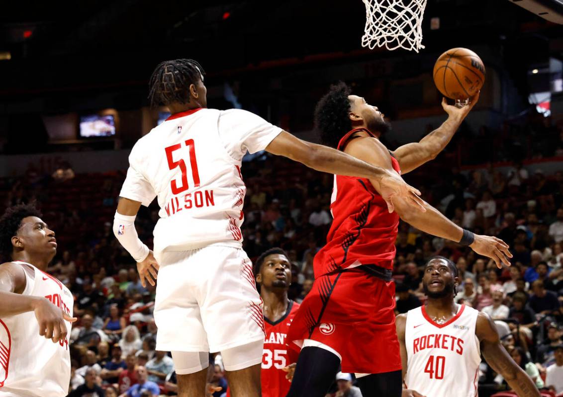 Atlanta Hawks forward Jacob Toppin, right, makes a layup around Houston Rockets guard Mylik Wil ...