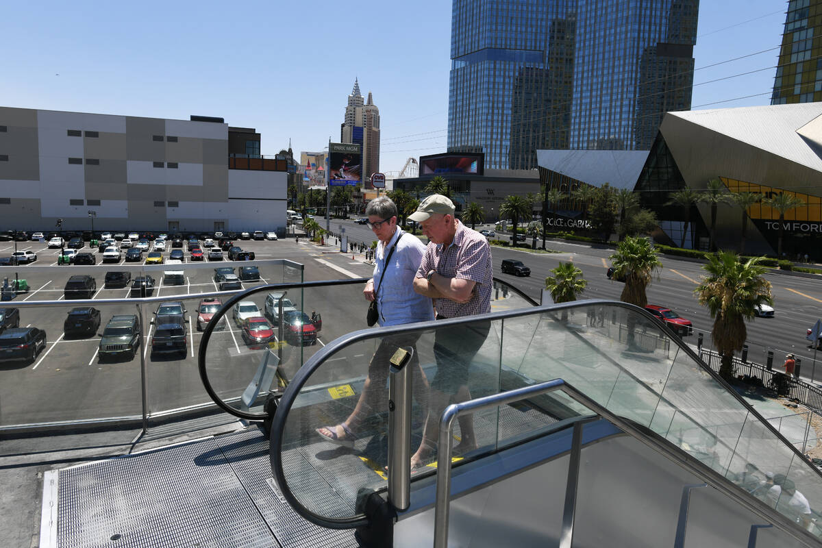 Pedestrians use an escalator on the corner of Harmon Avenue and the Strip where a parking lot o ...