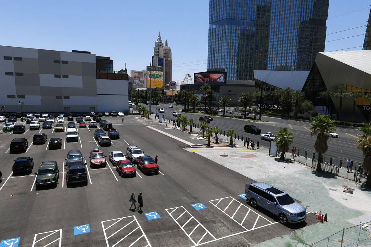 Pedestrians cross a parking lot owned by Tilman Fertitta on the corner of Harmon Avenue and the ...