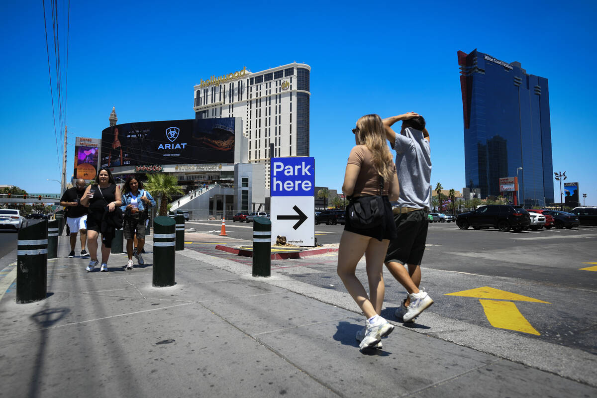 Pedestrians walk past a parking lot owned by Tilman Fertitta on the corner of Harmon Avenue and ...