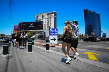 Pedestrians walk past a parking lot owned by Tilman Fertitta on the corner of Harmon Avenue and ...