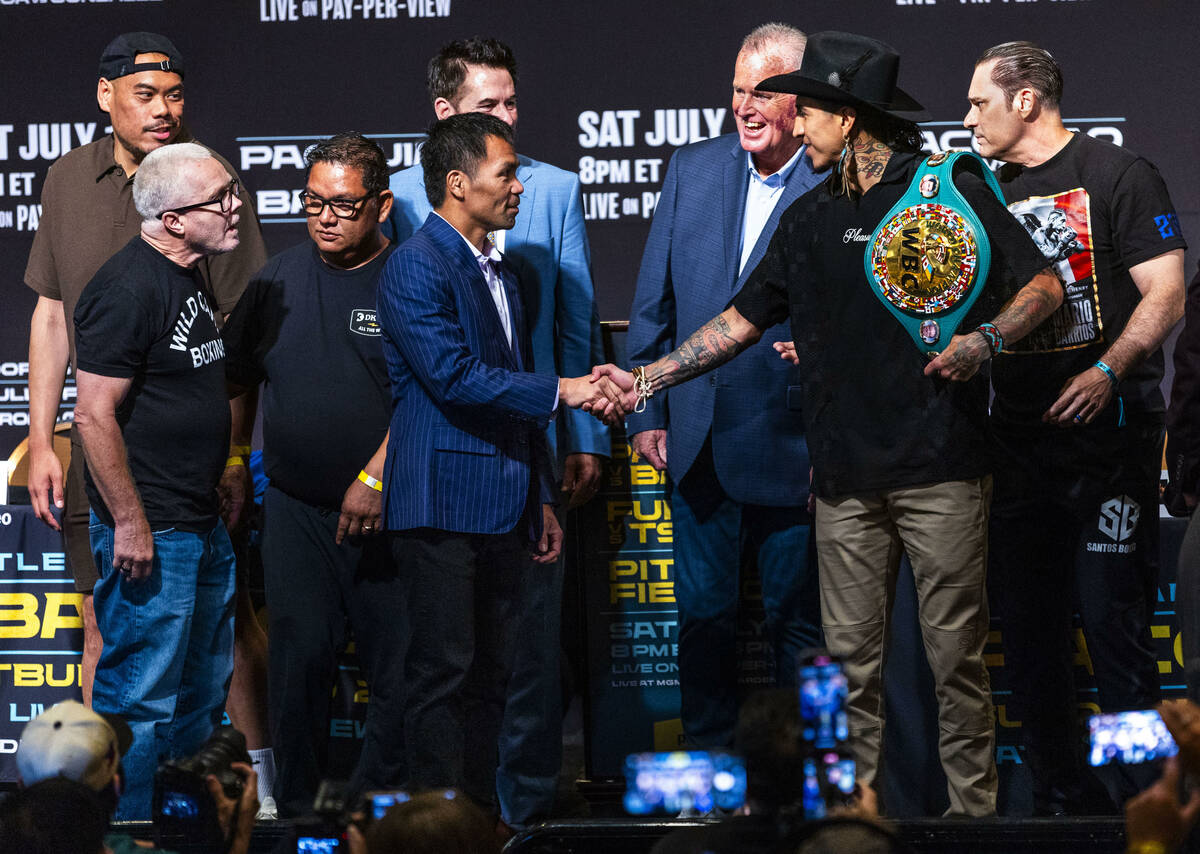 Manny Pacquiao and Mario Barrios shake after their face off for the crowd with their teams and ...