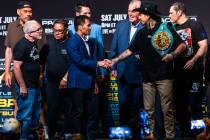 Manny Pacquiao and Mario Barrios shake after their face off for the crowd with their teams and ...
