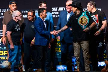 Manny Pacquiao and Mario Barrios shake after their face off for the crowd with their teams and ...