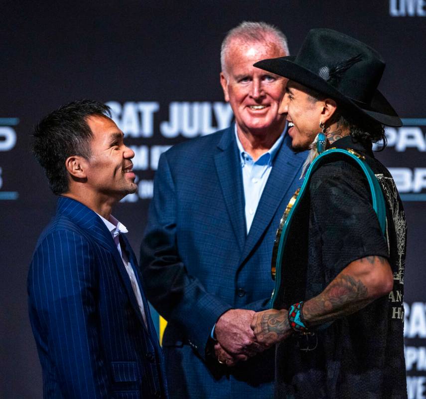 Manny Pacquiao and Mario Barrios face off for the crowd with promoter Tom Brown in between duri ...