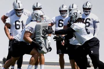 Raiders offensive tackle Kolton Miller (74) and guard Dylan Parham (66) work on drills during a ...