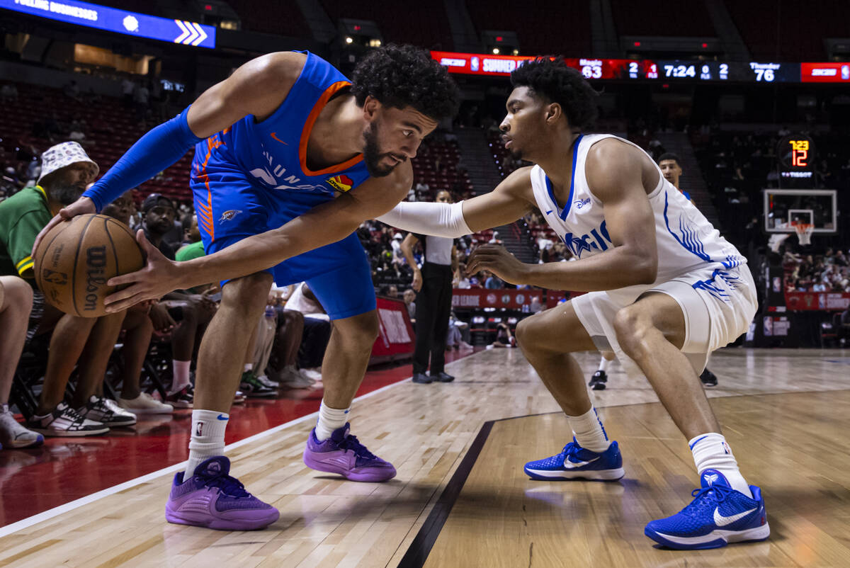Oklahoma City Thunder guard Ajay Mitchell, left, looks to get around Orlando Magic guard Jaden ...